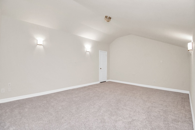 carpeted spare room featuring lofted ceiling