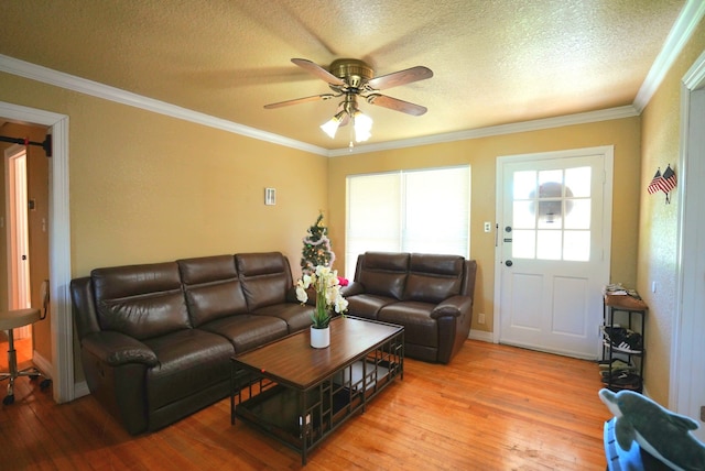 living room with a textured ceiling, hardwood / wood-style flooring, ceiling fan, and crown molding