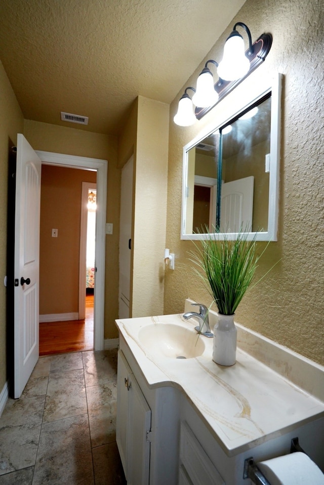 bathroom featuring tile patterned floors, vanity, and a textured ceiling