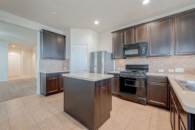 kitchen featuring a kitchen island, black appliances, and light tile patterned floors