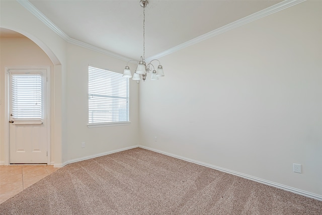 carpeted empty room featuring a chandelier and crown molding