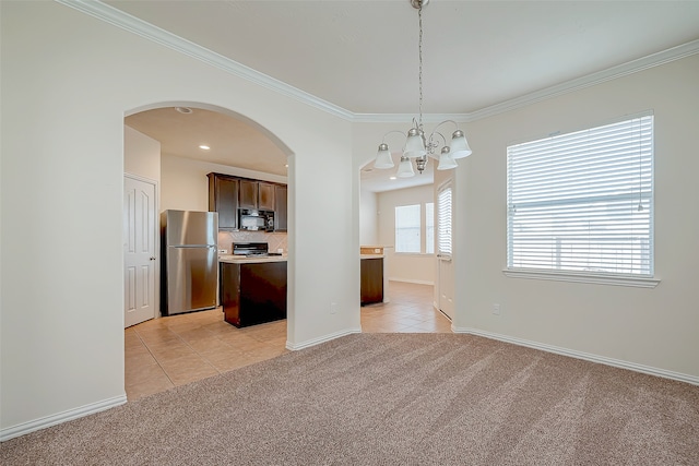 kitchen featuring hanging light fixtures, stainless steel appliances, light carpet, and an inviting chandelier