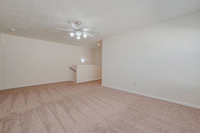 carpeted spare room with ceiling fan and a textured ceiling