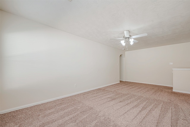 empty room with ceiling fan, carpet floors, and a textured ceiling