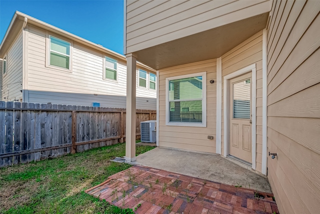 doorway to property with central air condition unit and a patio