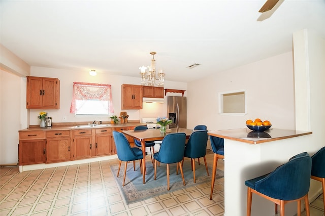 dining space with a chandelier and sink