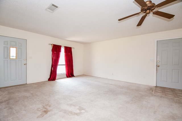 interior space featuring ceiling fan, carpet floors, and a textured ceiling