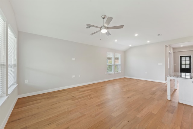 empty room featuring ceiling fan, lofted ceiling, and light hardwood / wood-style flooring