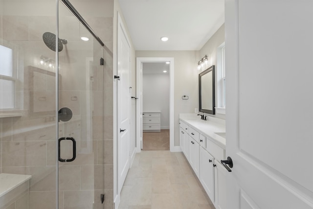 bathroom with tile patterned flooring, vanity, and walk in shower