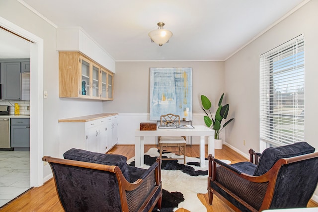 office area with light hardwood / wood-style floors and crown molding