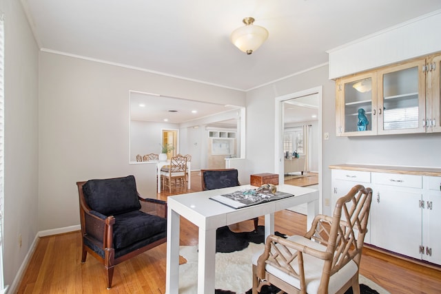 dining space featuring light wood-type flooring and ornamental molding