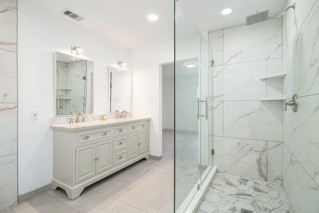 bathroom featuring a shower with door and vanity