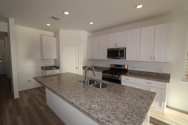 kitchen featuring white cabinetry, stainless steel appliances, sink, and a center island with sink