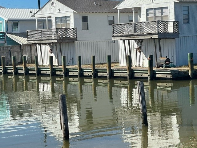 dock area with a balcony and a water view