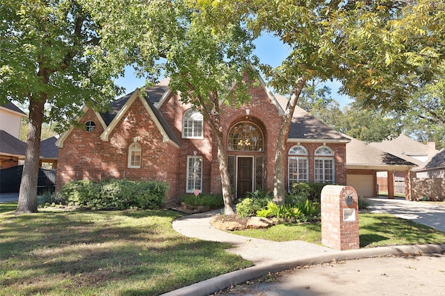 tudor home featuring a garage and a front yard