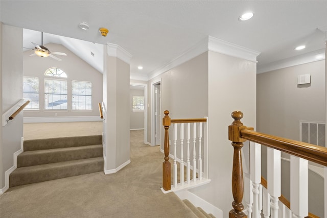 stairs with vaulted ceiling, carpet flooring, ceiling fan, and crown molding