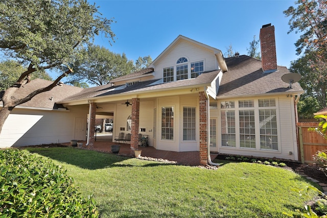 rear view of property featuring ceiling fan, a yard, and a patio area