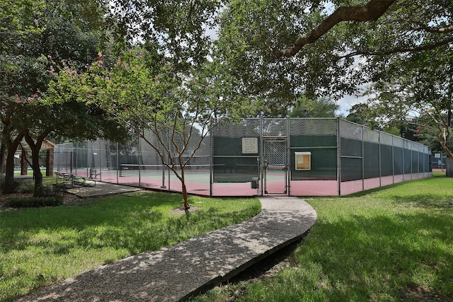 view of tennis court featuring a yard