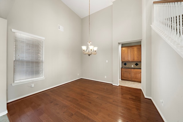 interior space featuring a notable chandelier, dark hardwood / wood-style floors, and high vaulted ceiling