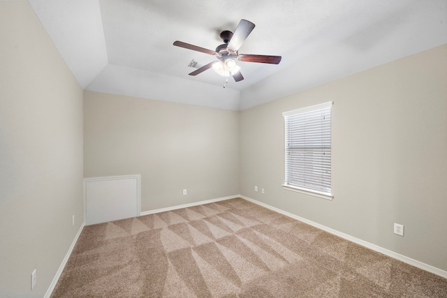 carpeted spare room with ceiling fan and lofted ceiling