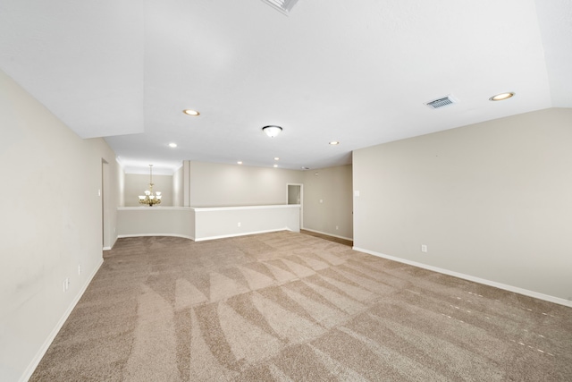 unfurnished room with light carpet, lofted ceiling, and a notable chandelier