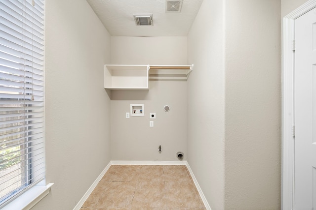 laundry area featuring washer hookup, hookup for an electric dryer, gas dryer hookup, a textured ceiling, and light tile patterned flooring