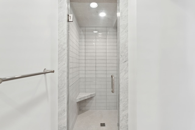 bathroom featuring a shower with door