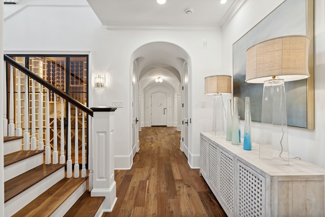 corridor with dark hardwood / wood-style flooring and ornamental molding