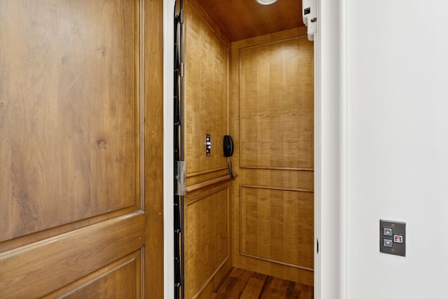 interior details with elevator and hardwood / wood-style floors