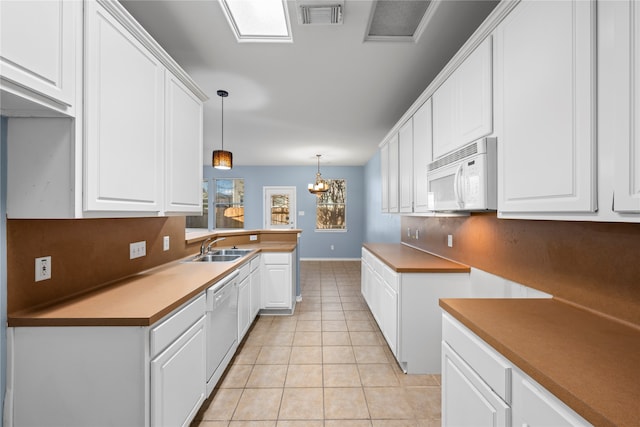 kitchen featuring white cabinetry, white appliances, hanging light fixtures, and light tile patterned floors