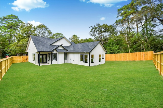 rear view of house featuring a yard