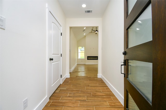 hallway featuring lofted ceiling and light wood-type flooring