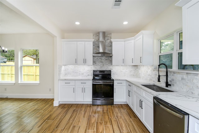 kitchen with black electric range oven, a wealth of natural light, dishwasher, and wall chimney exhaust hood