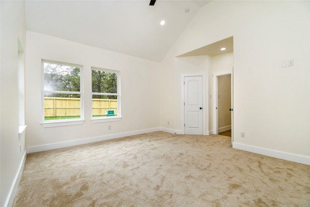 spare room with light colored carpet and high vaulted ceiling