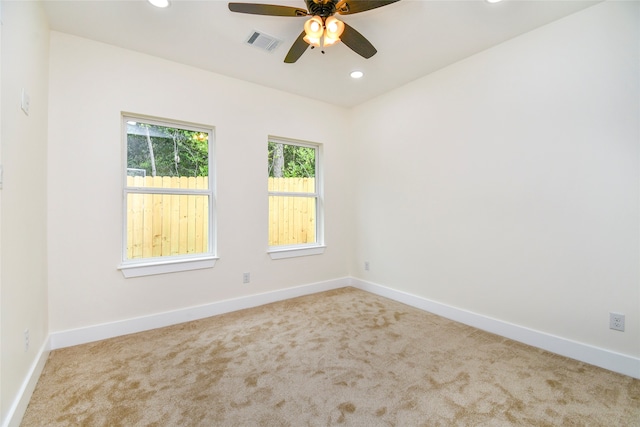 empty room featuring ceiling fan and light colored carpet