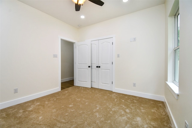 unfurnished bedroom featuring carpet, a closet, and ceiling fan