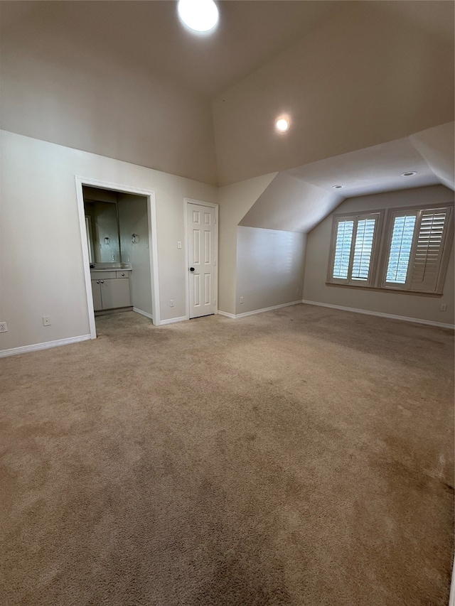 additional living space featuring lofted ceiling and carpet floors