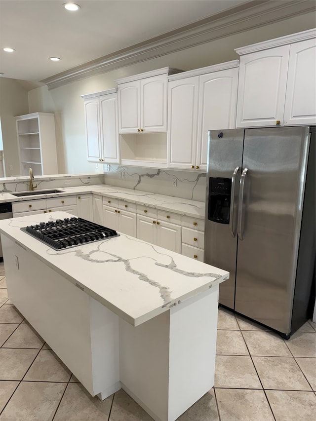 kitchen featuring white cabinets, sink, light stone countertops, ornamental molding, and stainless steel appliances