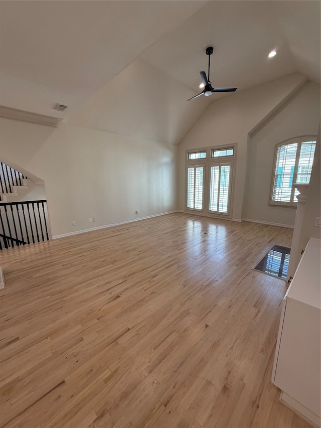 unfurnished living room featuring light wood-type flooring, vaulted ceiling, and ceiling fan