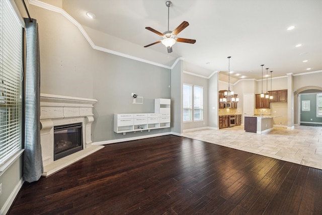 unfurnished living room with ceiling fan, light hardwood / wood-style floors, and ornamental molding