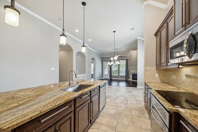 kitchen featuring hanging light fixtures, crown molding, sink, and appliances with stainless steel finishes