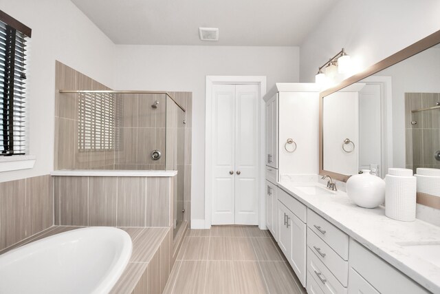 bathroom featuring vanity, tile patterned floors, plenty of natural light, and independent shower and bath