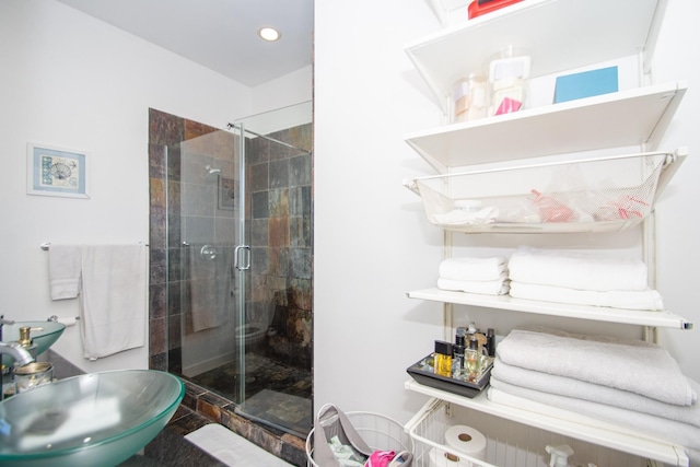 bathroom with a shower with door and sink