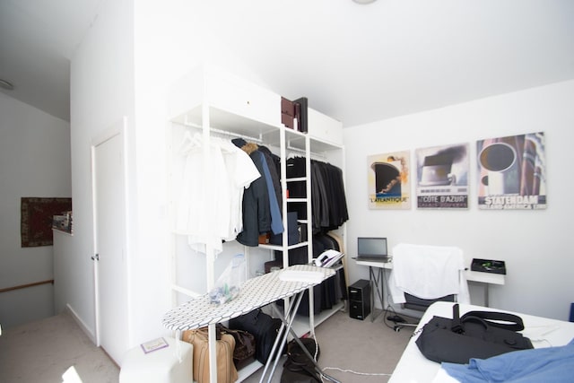 walk in closet featuring light colored carpet and lofted ceiling