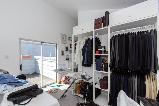 walk in closet with carpet floors and vaulted ceiling