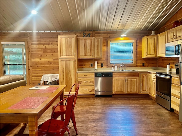 kitchen featuring light brown cabinets, sink, stainless steel appliances, dark hardwood / wood-style flooring, and wood walls