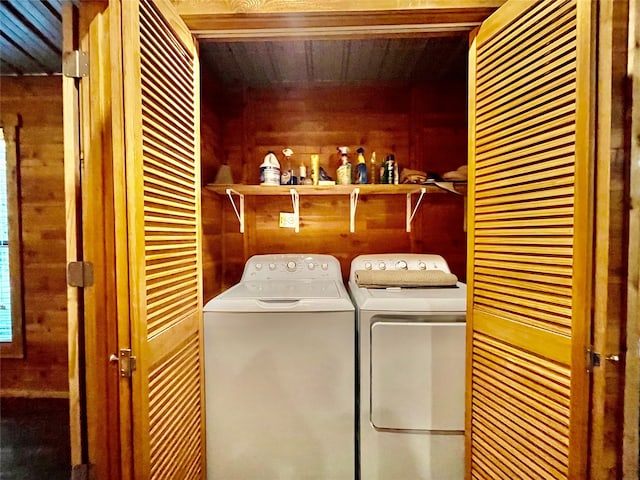 laundry area featuring separate washer and dryer, wooden walls, and wood ceiling