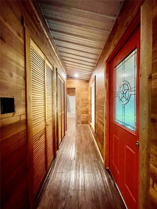 hall featuring wood walls, hardwood / wood-style floors, and wooden ceiling