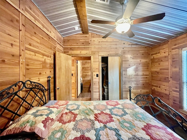 bedroom featuring vaulted ceiling with beams, wooden walls, and ceiling fan