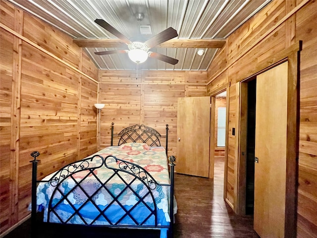 unfurnished bedroom featuring lofted ceiling with beams, wood walls, dark hardwood / wood-style flooring, and ceiling fan